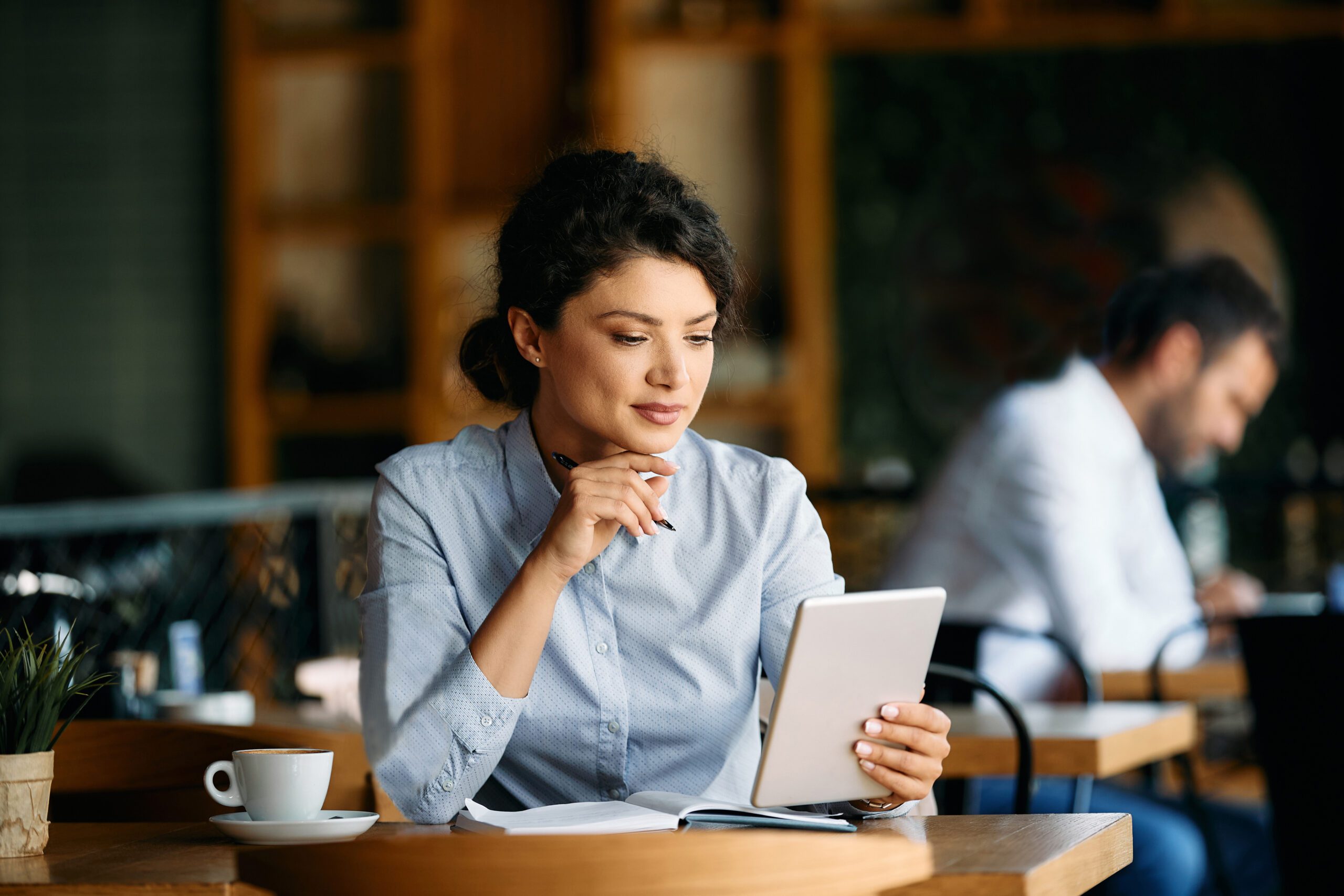 Femme réservant un séjour multiactivité sur tablette pour un hôtel resort haut de gamme